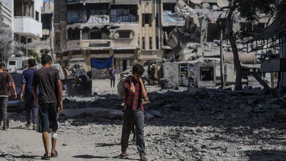 Gaza, Pojas Gaze, dečak hoda po ruševinama u Gazi, noseći džak