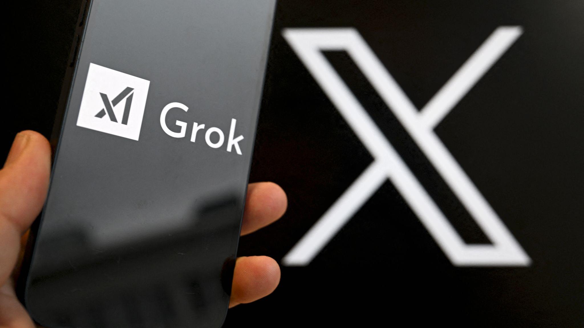 設計圖片：一部展示著Grok商標的手機置於展現X商標的一面牆前面