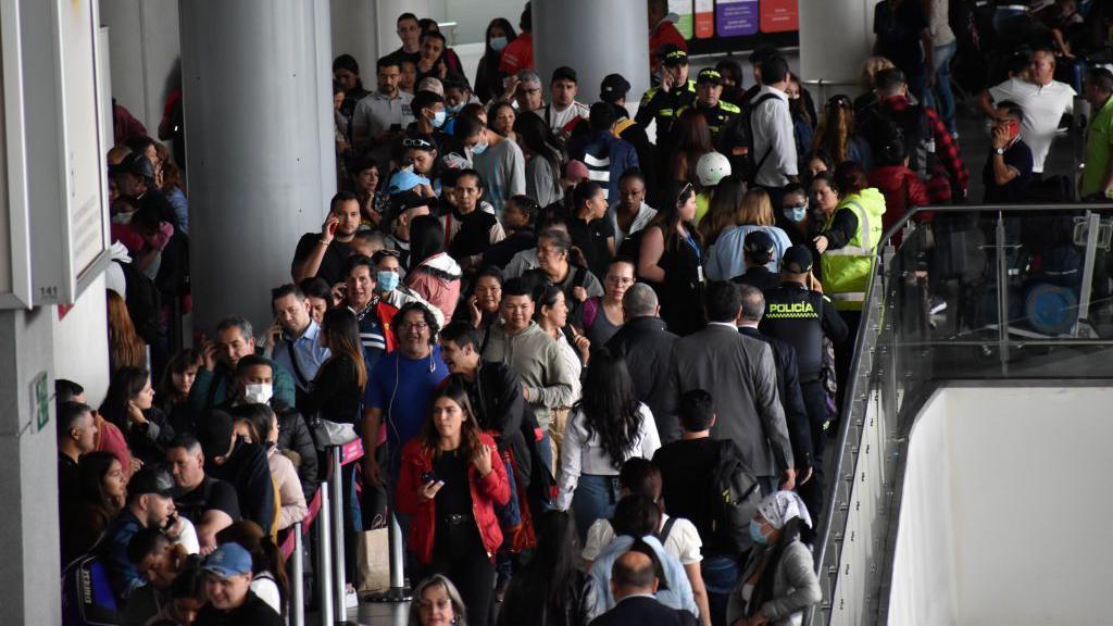 Personas en el aeropuerto El Dorado un día de cancelación de vuelos.