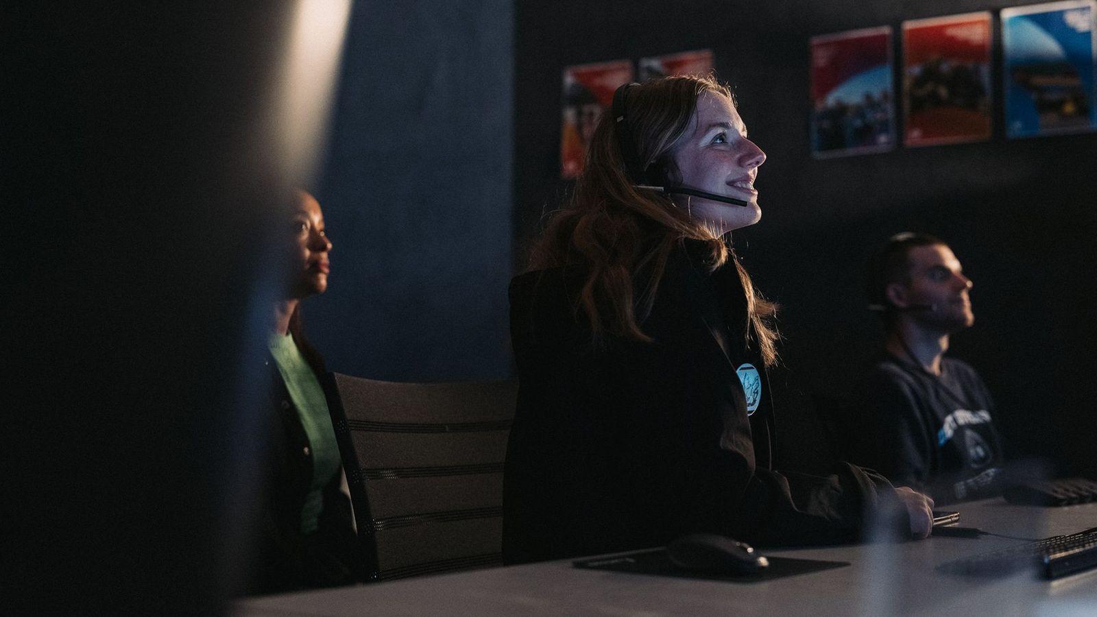 Personas dentro de un centro de comando espacial. 