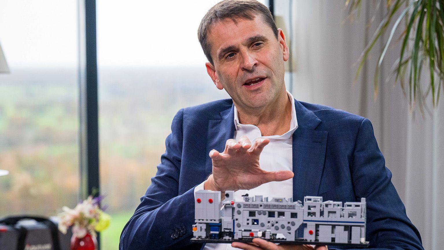 Christophe Fouquet, diretor-executivo da ASML Holding NV, segura um modelo de uma m&aacute;quina de litografia de semicondutores