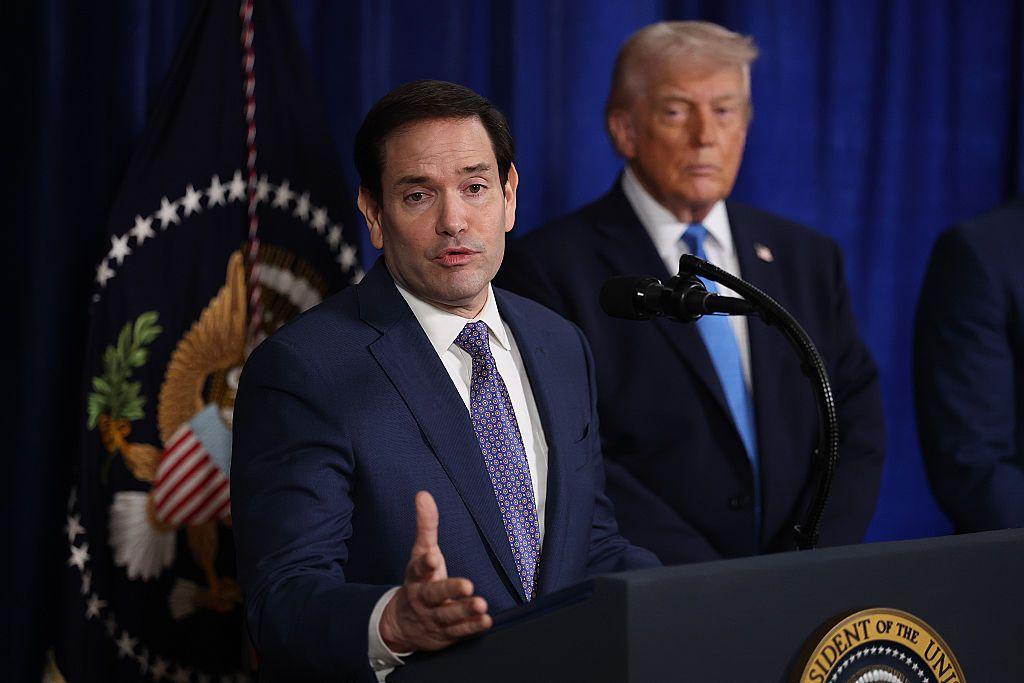 Marco Rubio da una conferencia de prensa. Atrás se ve al presidente Donald Trump. 