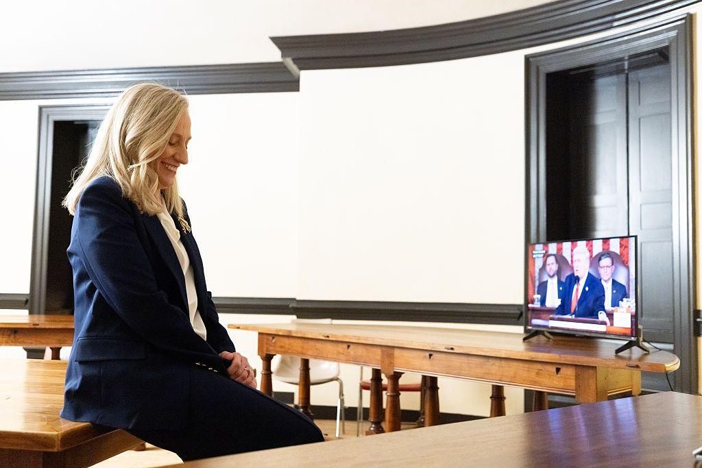 La gobernadora de Virgina escucha el discurso de Trump con una sonrisa en su cara.