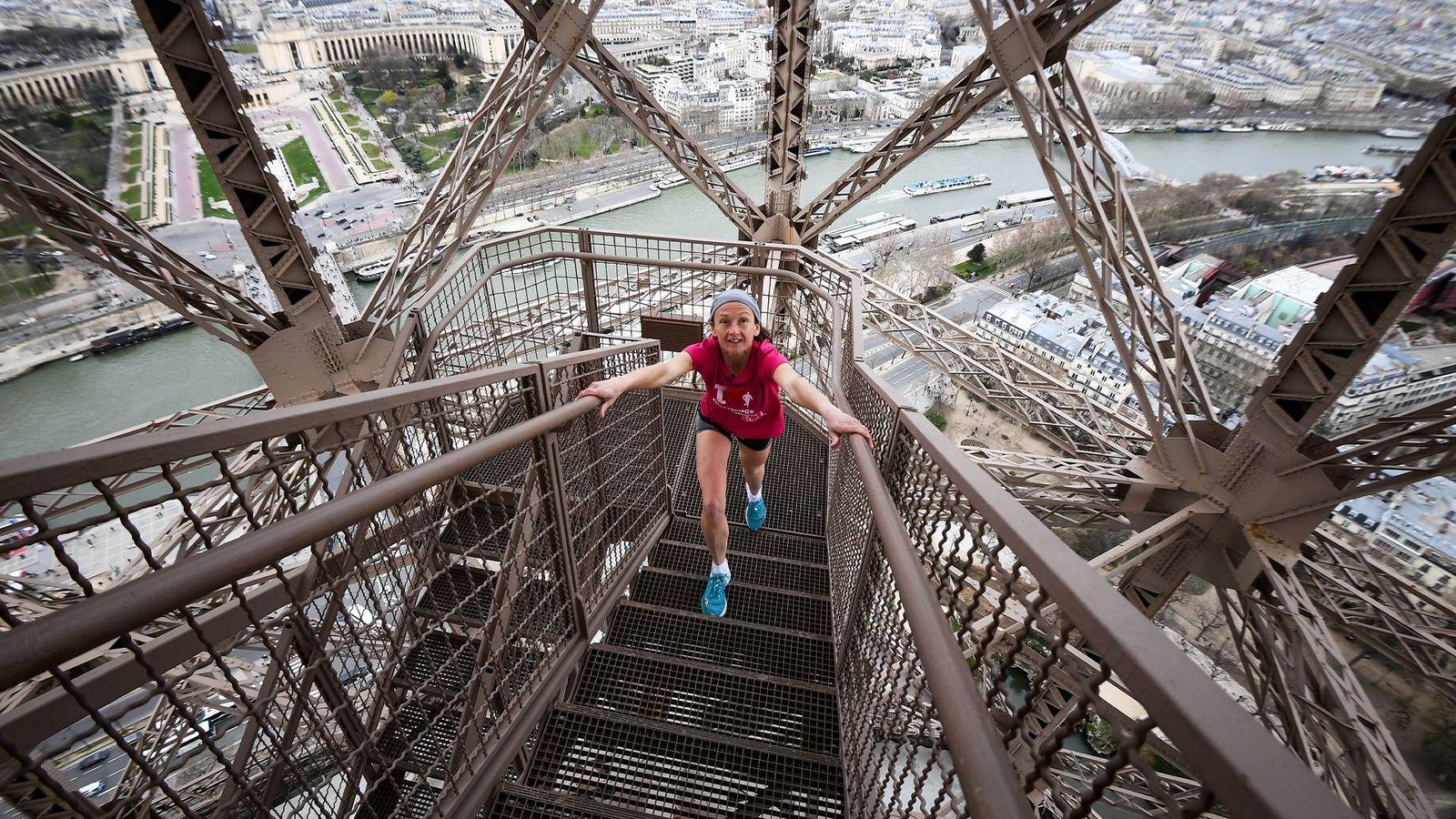 Persona subiendo los escalones de la Torre Eiffel. 