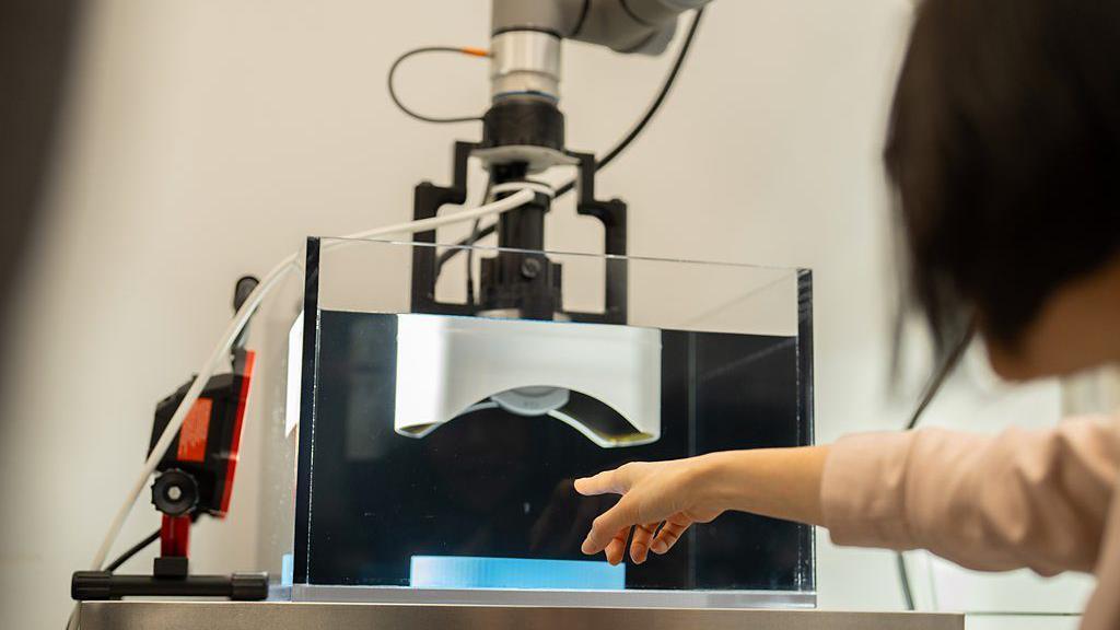 La científica Zhen Xu señala una máquina de su laboratorio
