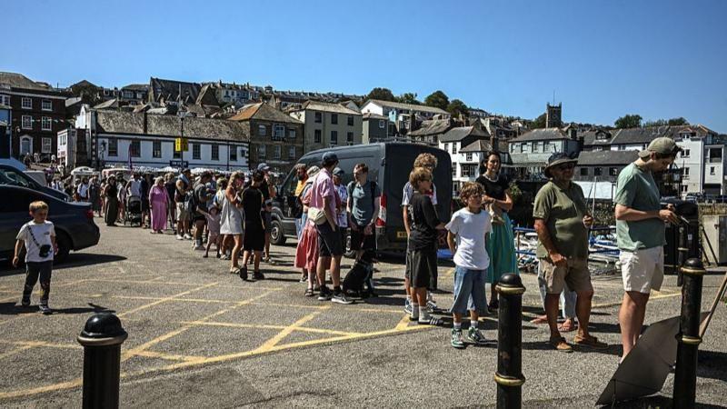Pessoas fazem fila em Falmouth, na Inglaterra, para comprar &oacute;culos de prote&ccedil;&atilde;o para observar o eclipse solar