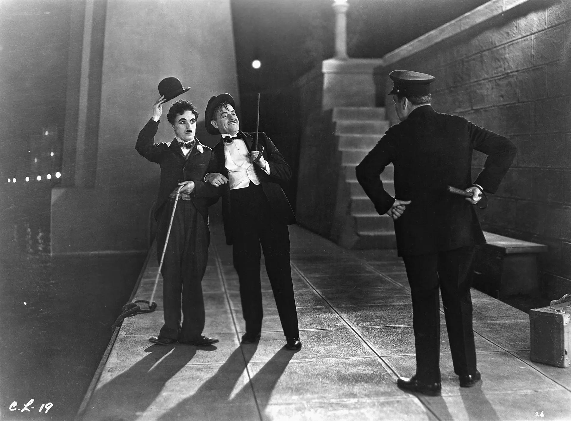 Chaplin, en una de las emblemáticas escenas de City Lights, junto a su compañero, y los dos están frente a un policía que los mira con pose de reproche