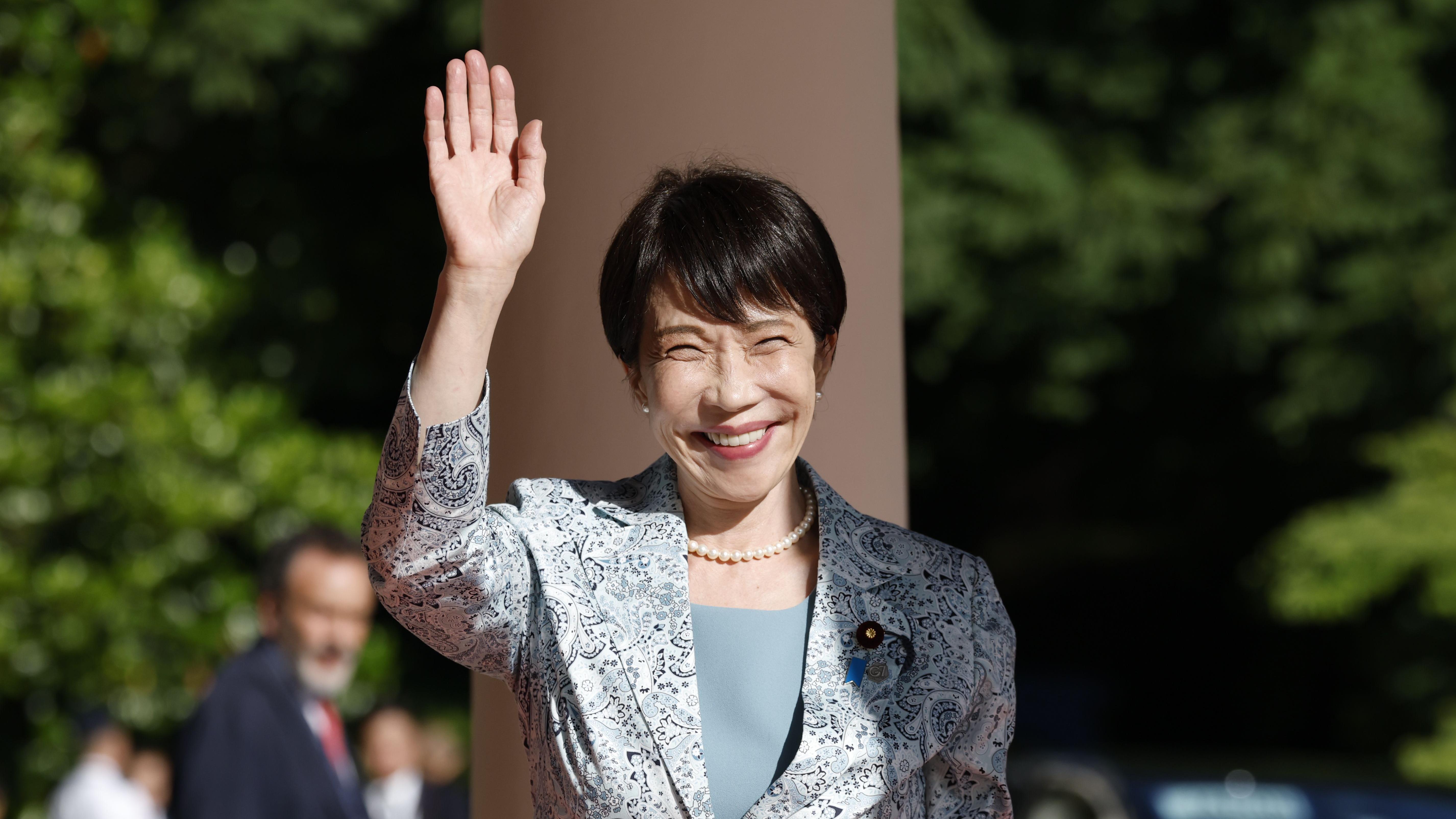 Sanae Takaichi levanta la mano y sonríe