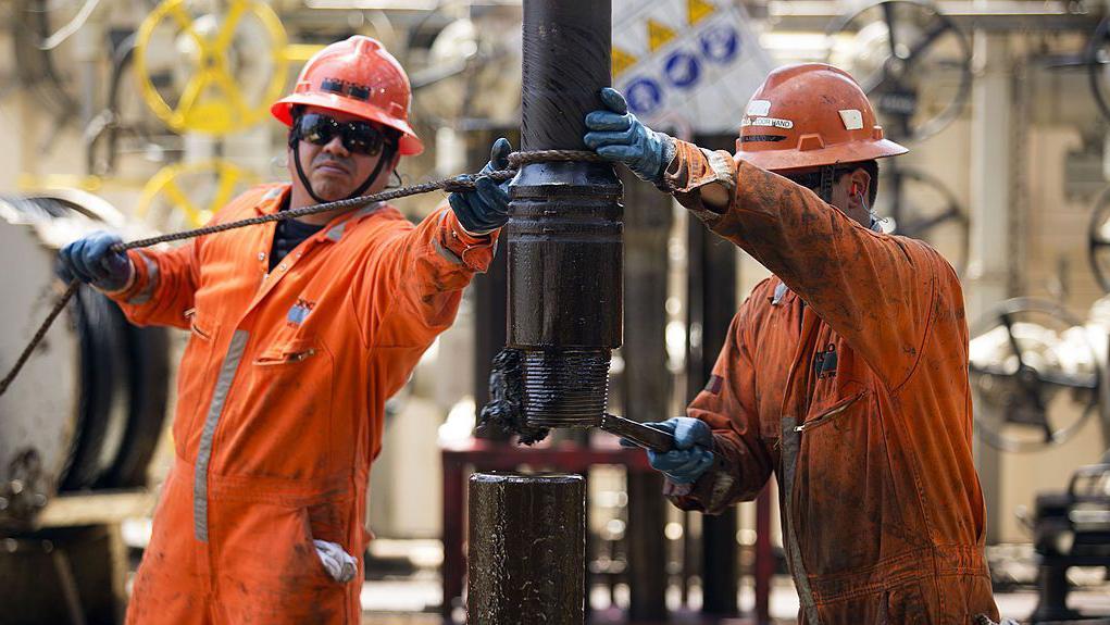 Trabajadores con un mono naranja cambian una tubería de perforación en la plataforma petrolífera Laurus, en la bahía de Campeche