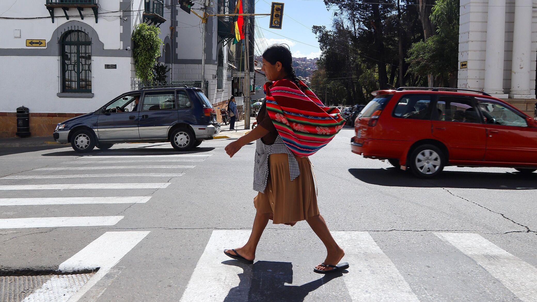 Un mujer camina por la calle en Bolivia.