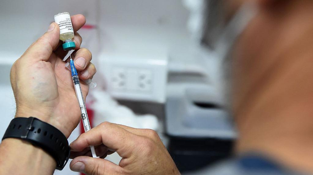 Un médico argentino mientras prepara una inyección