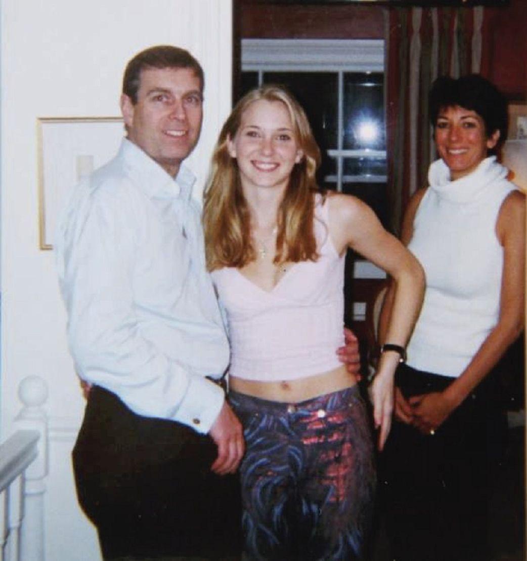 Andrew wearing a blue shirt with black trousers, standing next to Virginia Giuffre, with his arm around her waist. Ms Guiffre is wearing a tight tank top, revealing her lower stomach and multicoloured trousers with purple and pink patterns on them. Ghislaine Maxwell is standing behind them, leaning backwards a little. She is wearing a white top with a large circular collar that reveals her arms from her shoulders. All three are smiling.