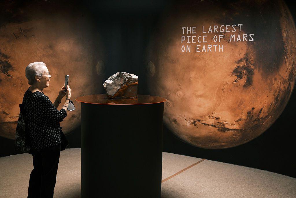 Una mujer fotografía el meteorito que fue subastado por Sotheby's por más de US$ 4 millones.