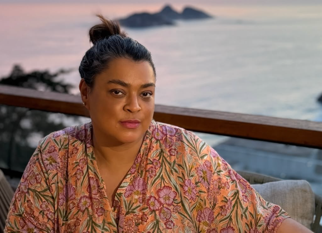 Preta Gil em sacada, com o mar ao fundo