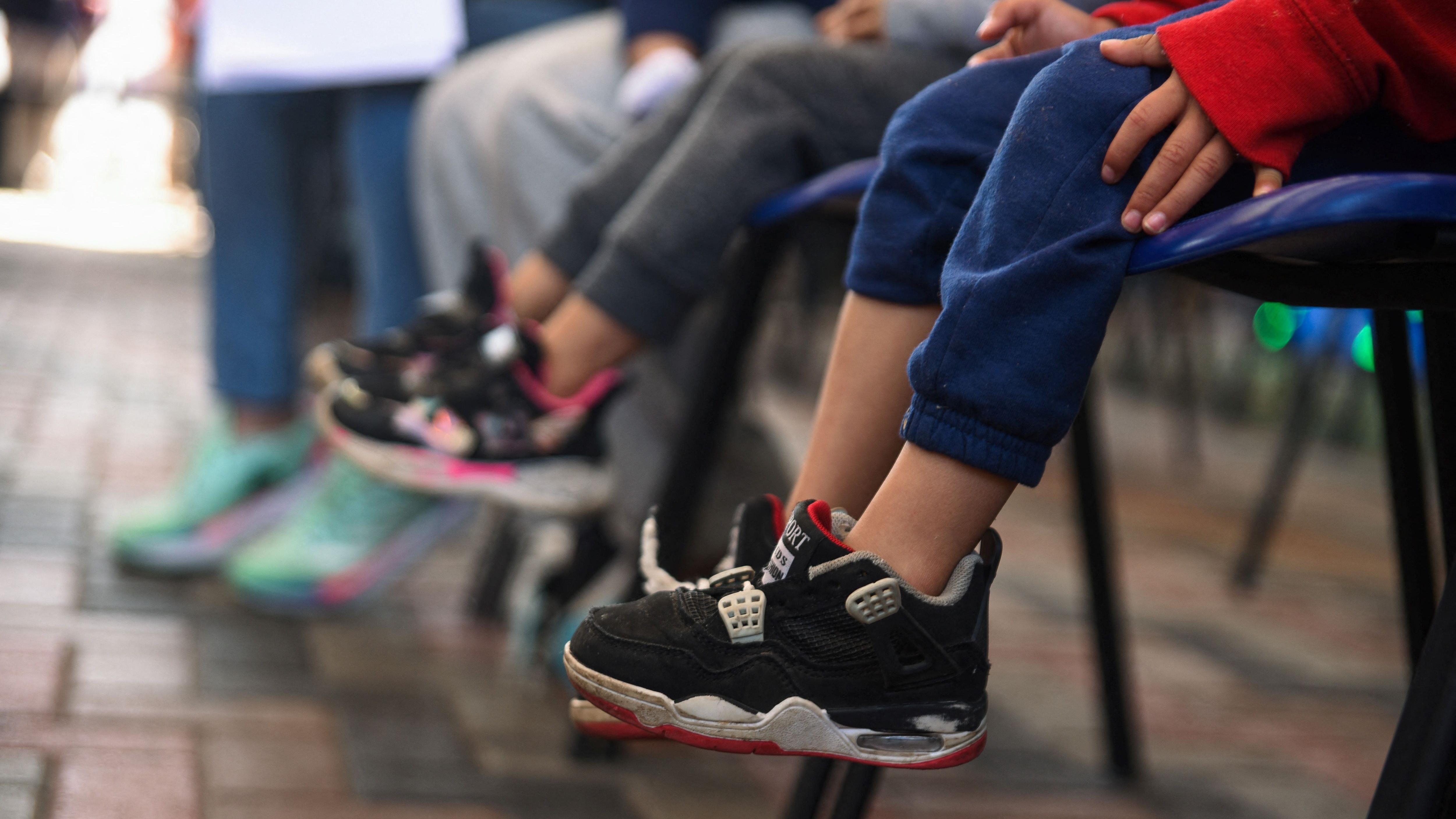 Niños deportados, junto a sus padres, esperan en una oficina de migración.