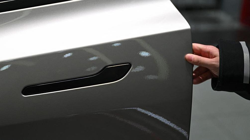 2026年2月3日，一名女子在北京一家特斯拉展廳為一輛特斯拉Model YL電動車打開車門。