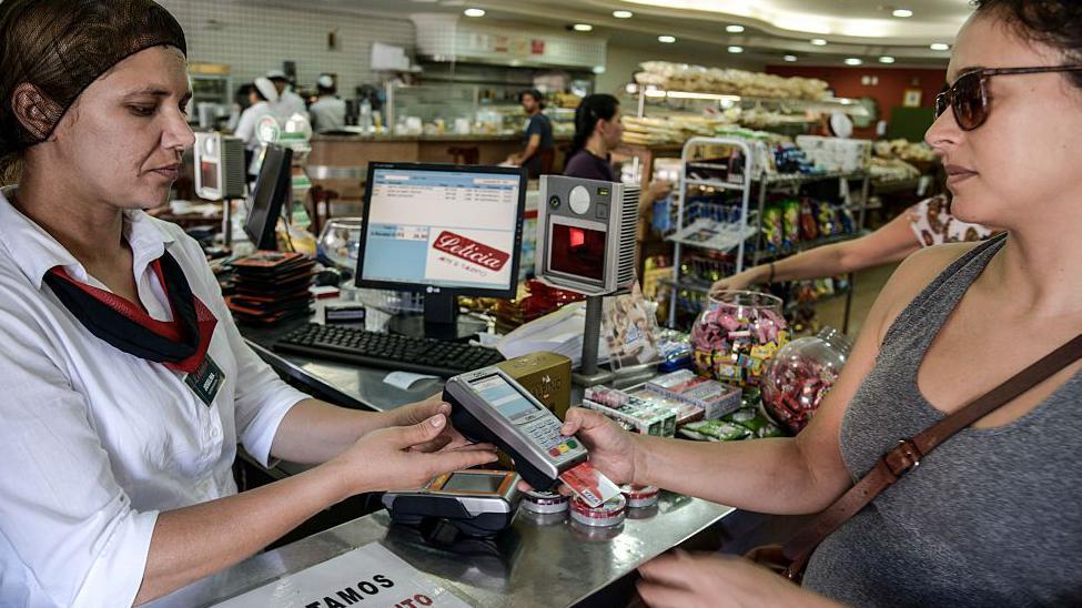 Mulher pagando conta em padaria