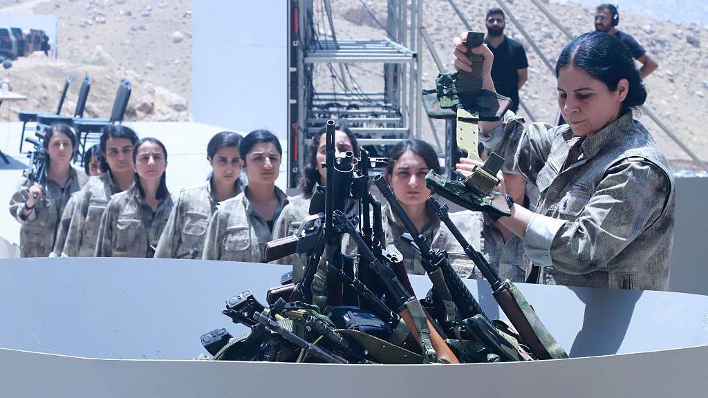 Combatientes del Partido de los Trabajadores del Kurdistán (PKK) se alinean para depositar sus armas en un pozo durante una ceremonia en Sulaimaniyah, en la región autónoma del Kurdistán iraquí.
