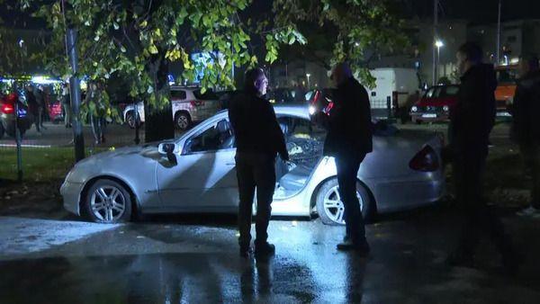 Dvojica muškaraca ispred automobila sa lampama u rukama