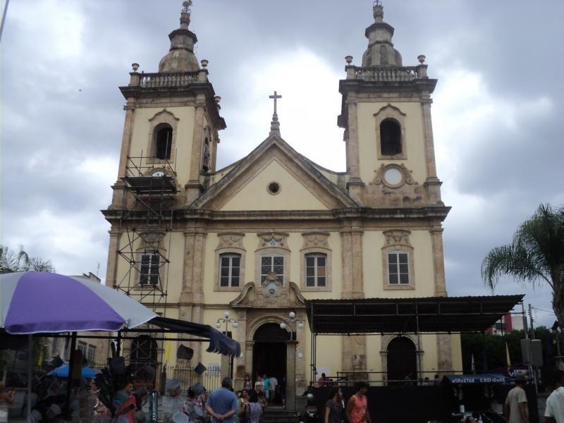 Antiga Igreja de Aparecida num dia de céu nublado, com vendedores ambulantes à frente