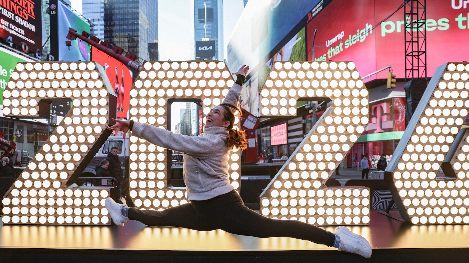 Šta nas čeka u 2026. na Balkanu, u svetu i na nebu 1 Devojka u trenerci skače ispred svetlećeg znaka na njujorškom Tajms Skveru