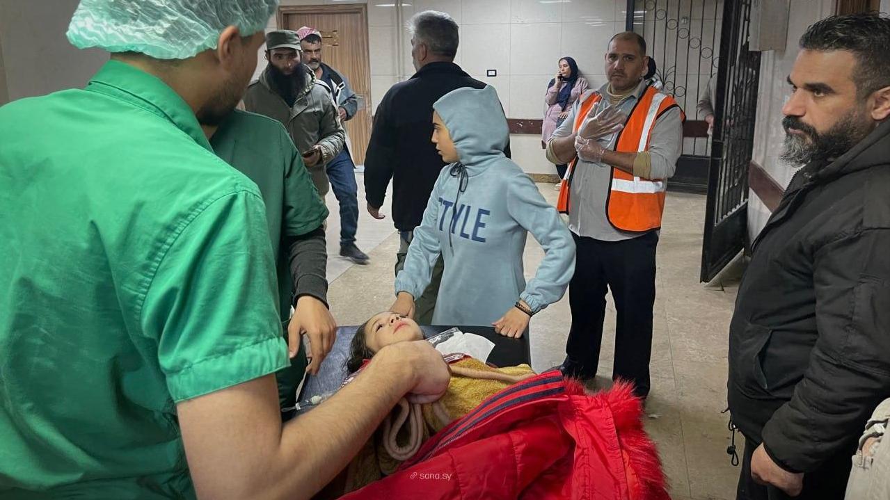 طفلة مصابة بين طاقم طبي في مستشفى