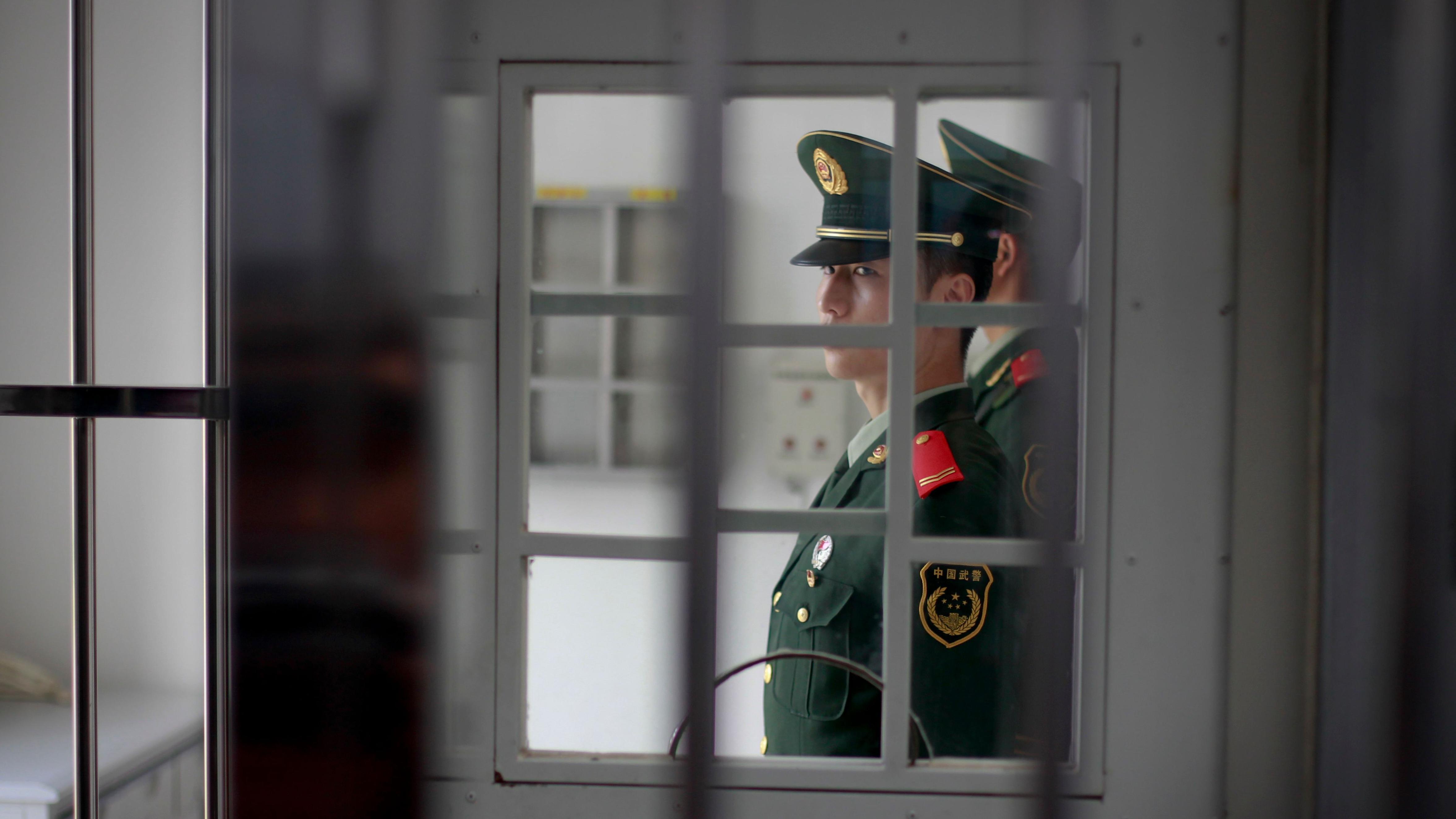Un guardia, visto entre las rejas de cárcel.