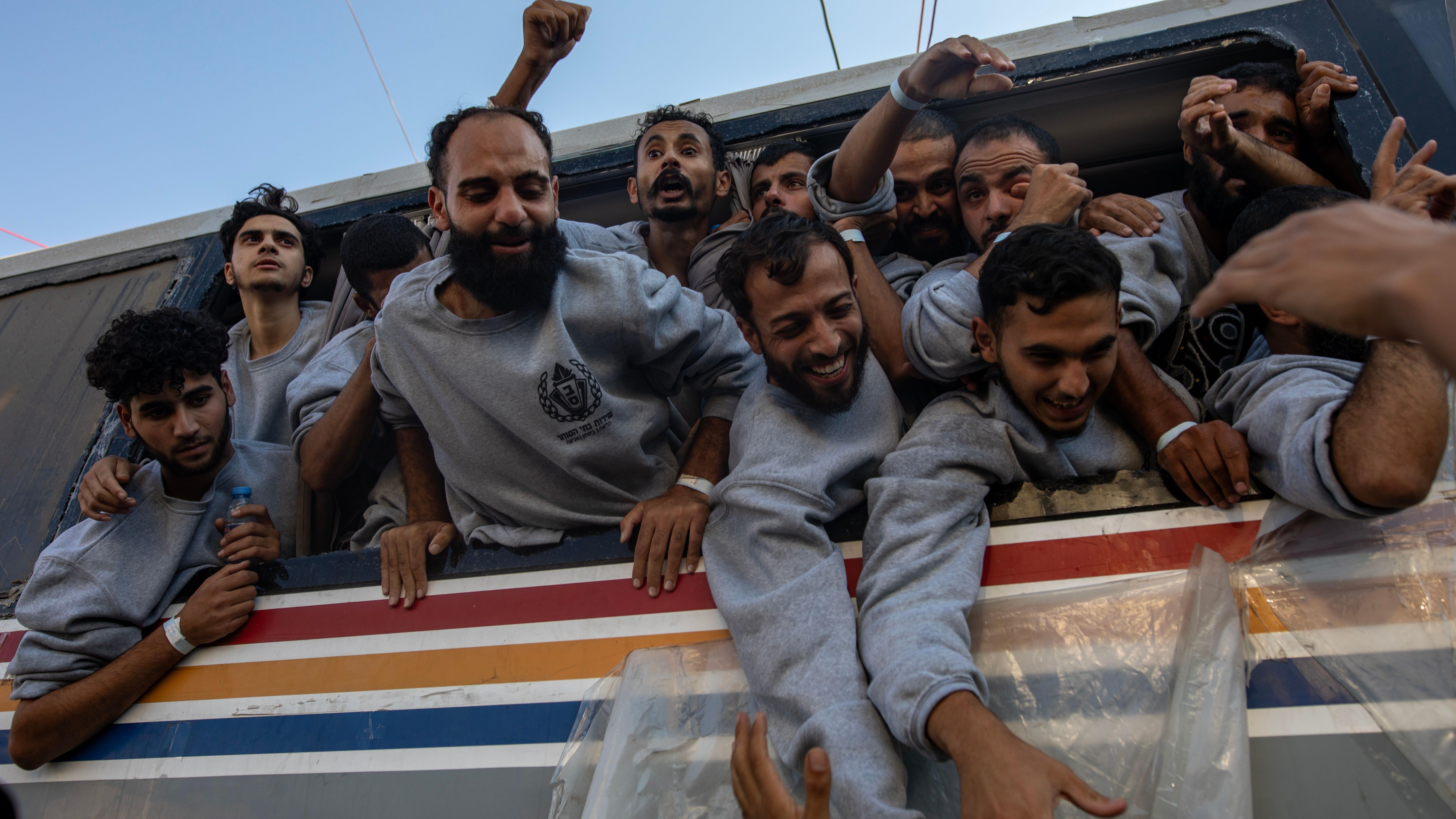 Un grupo de prisioneros palestinos liberados asomando por las ventanas de un autobús.