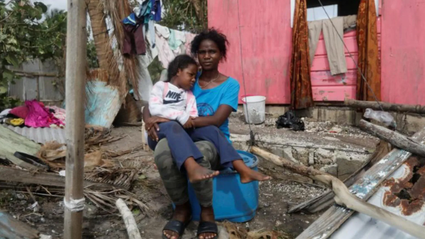 سيدة تحمل طفلة في حُضنها.