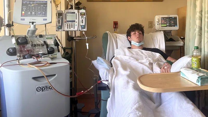 Um jovem deitado em uma cama de hospital fazendo exames