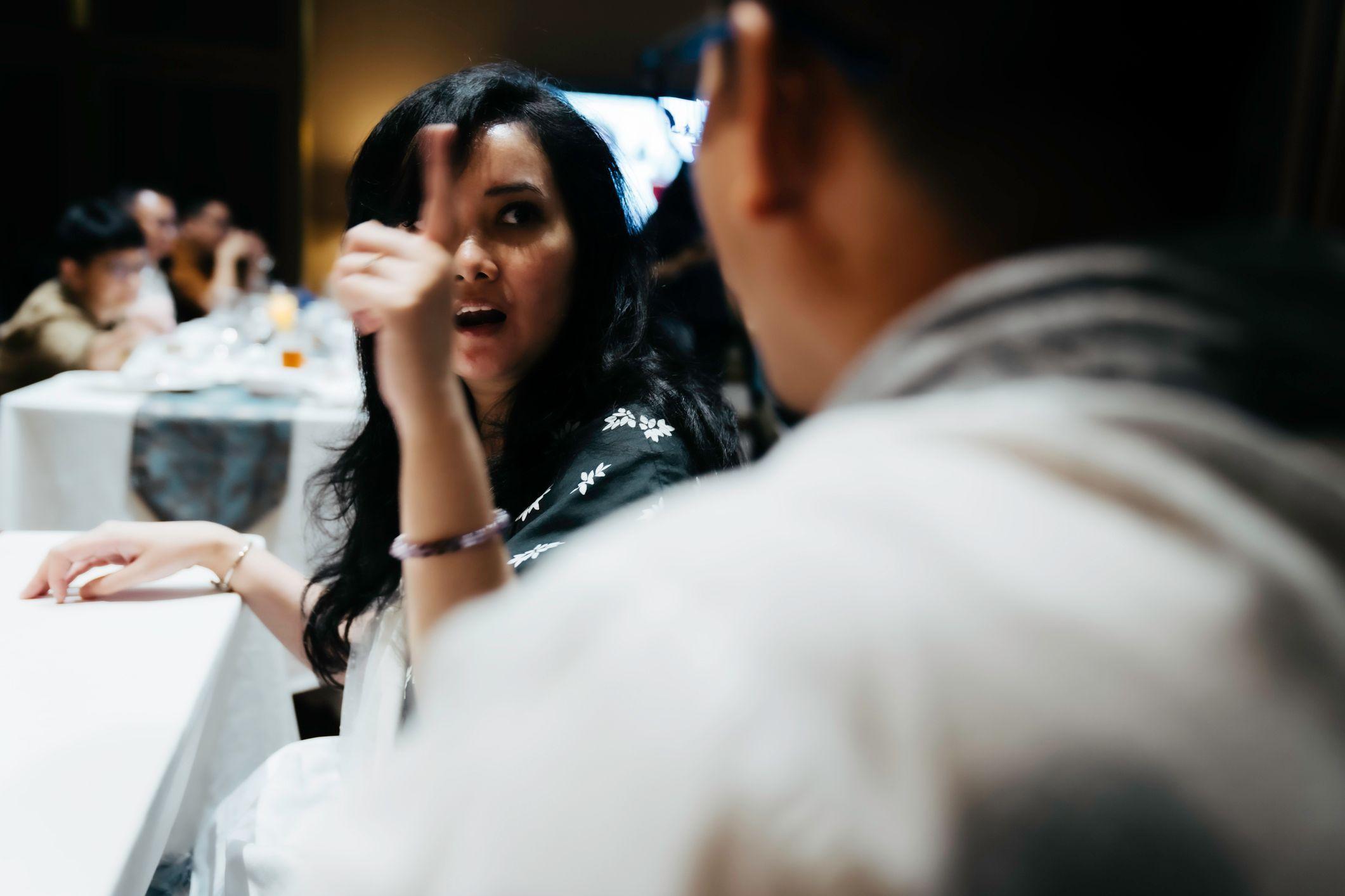 Una mujer discute con un hombre en una mesa de una reunión familiar