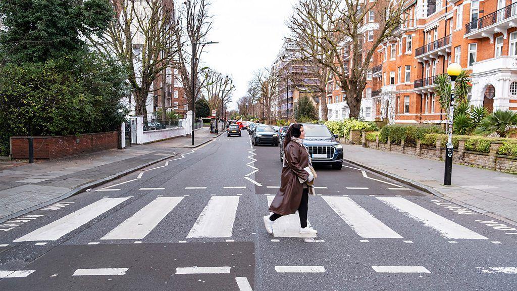 Pessoa atravessando a rua de uma cidade na faixa de segurança
