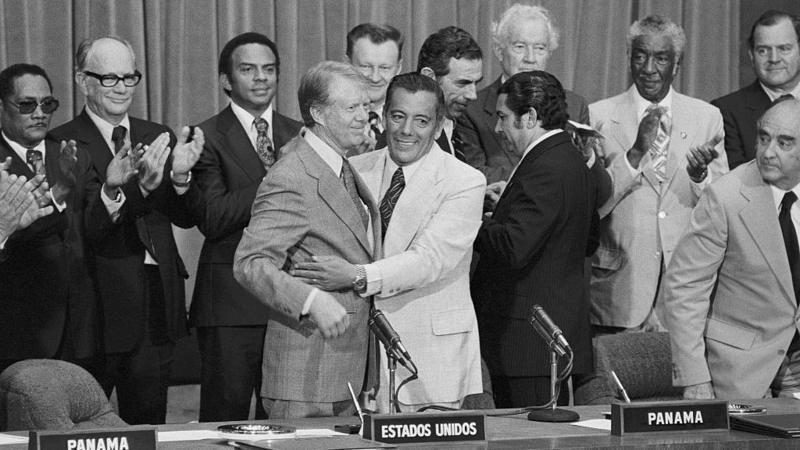 Presidente americano Jimmy Carter e o general panamenho Omar Torrijos celebram a assinatura dos acordos sobre o Canal do Panamá em 1977, ao lado de outras autoridades