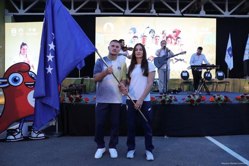 Irmãos segurando bandeira em frente a palco com banda tocando