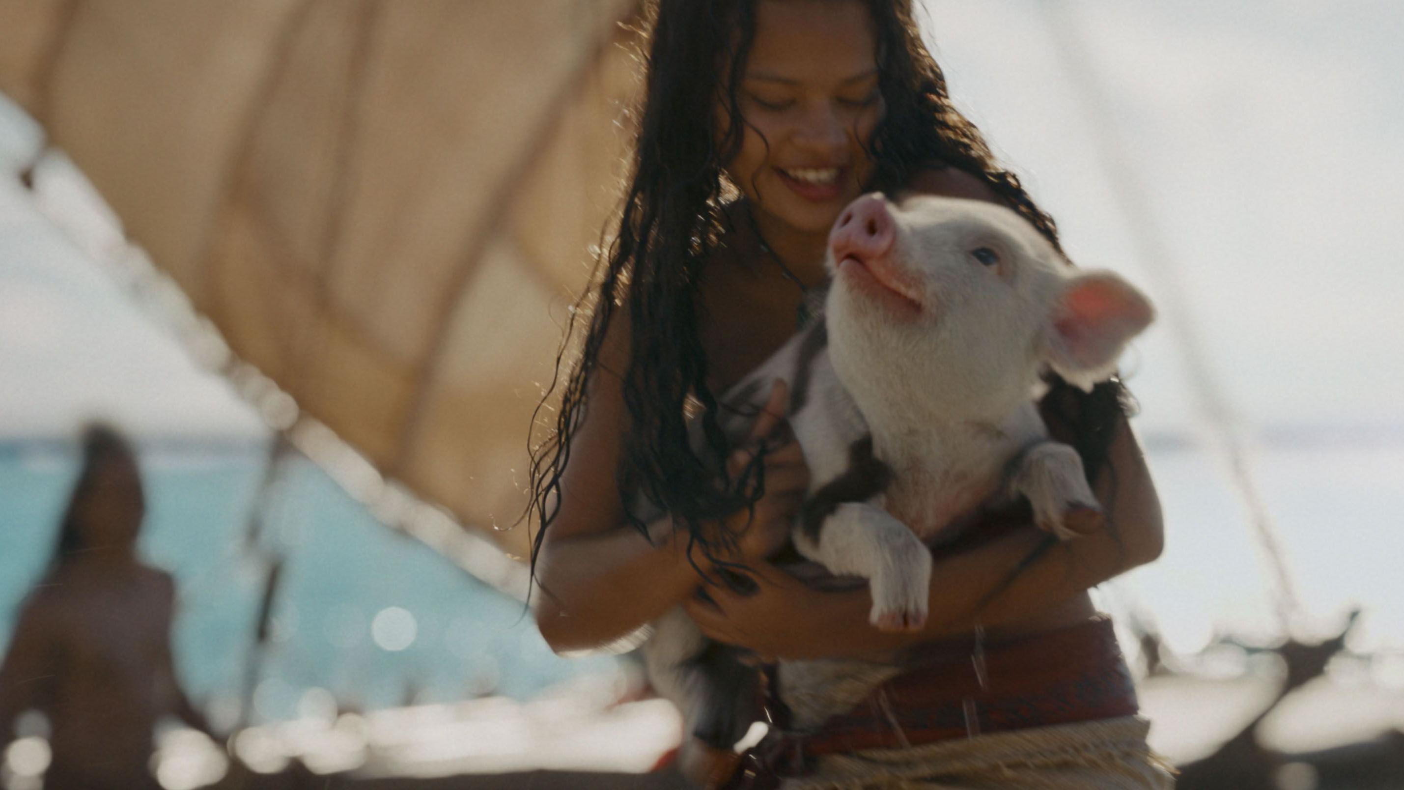 Catherine Laga'aia segura um porco em uma cena do remake em live-action de Moana, lan&ccedil;ado em 2026