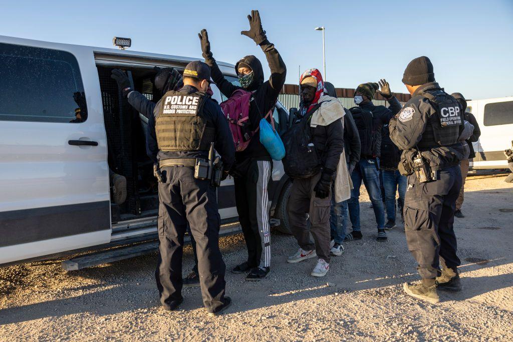 Un oficial de Aduanas y Protección Fronteriza de EE.UU. revisa a inmigrantes antes de transportarlos desde la frontera entre EE. UU. y México el 08 de diciembre de 2023 en Lukeville, Arizona.  (Foto de John Moore/Getty Images)