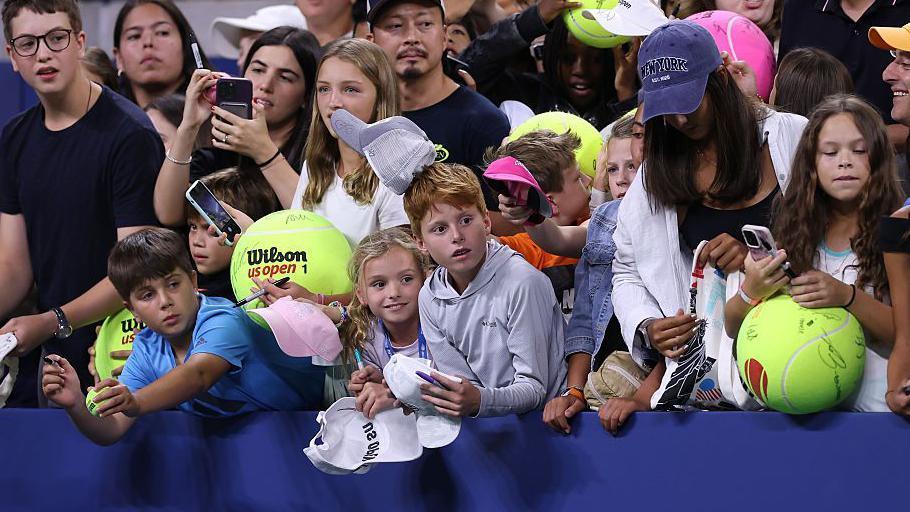 Niños esperan autógrafos en un partido del US Open