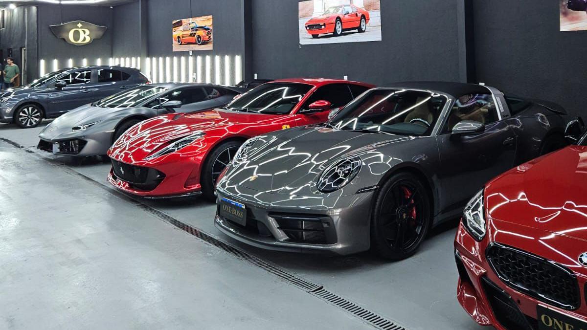 Carros de luxo lado a lado dentro de concessionária