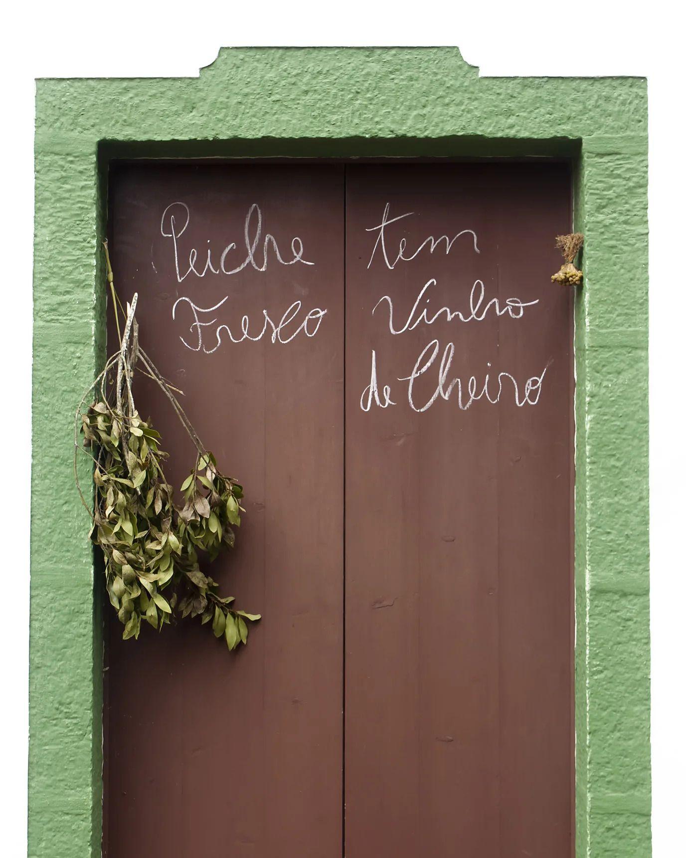 綠色樹枝掛在紅色的門上，門上寫有英文字