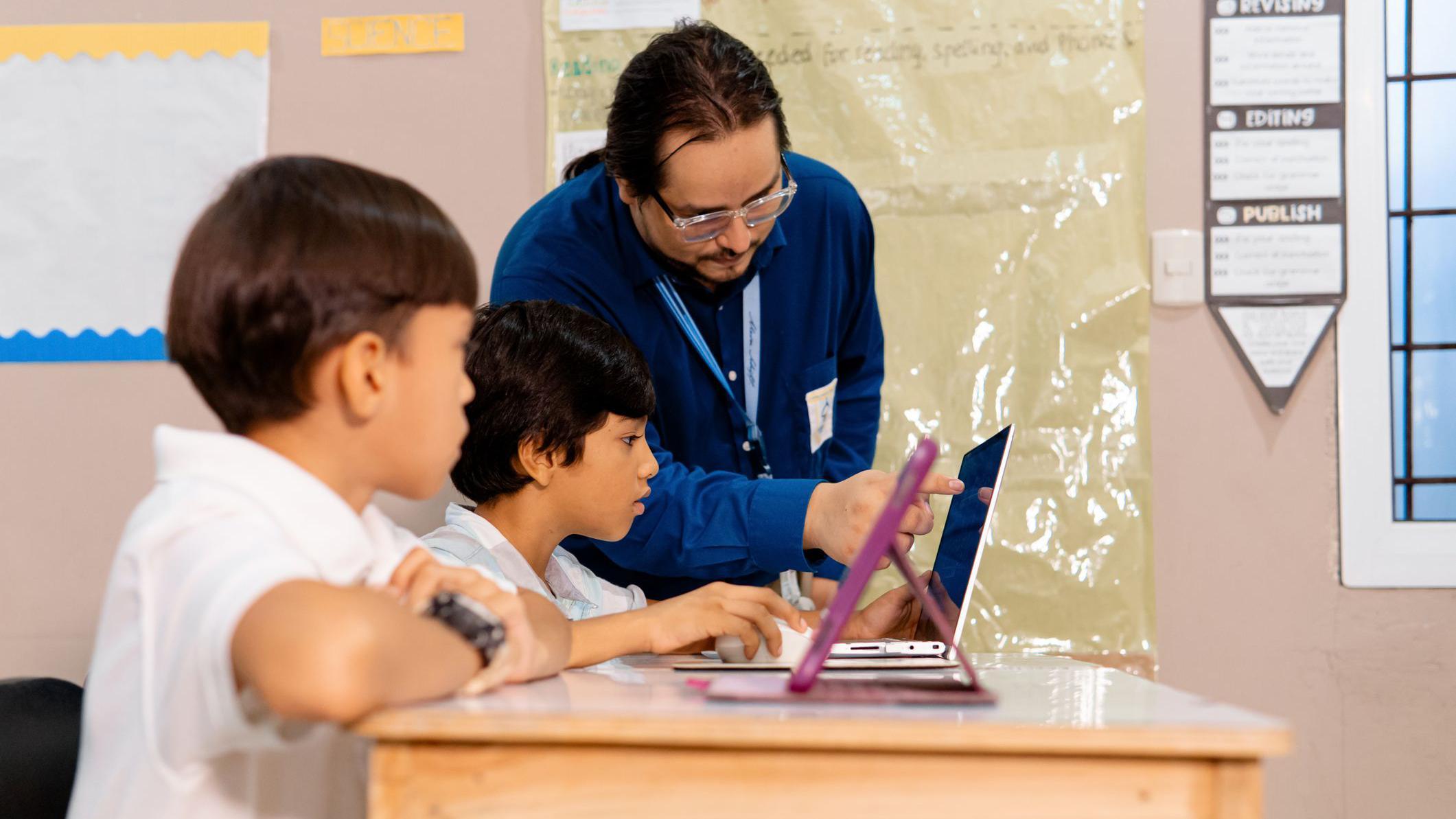 Un maestro con dos alumnos de escuela primaria.