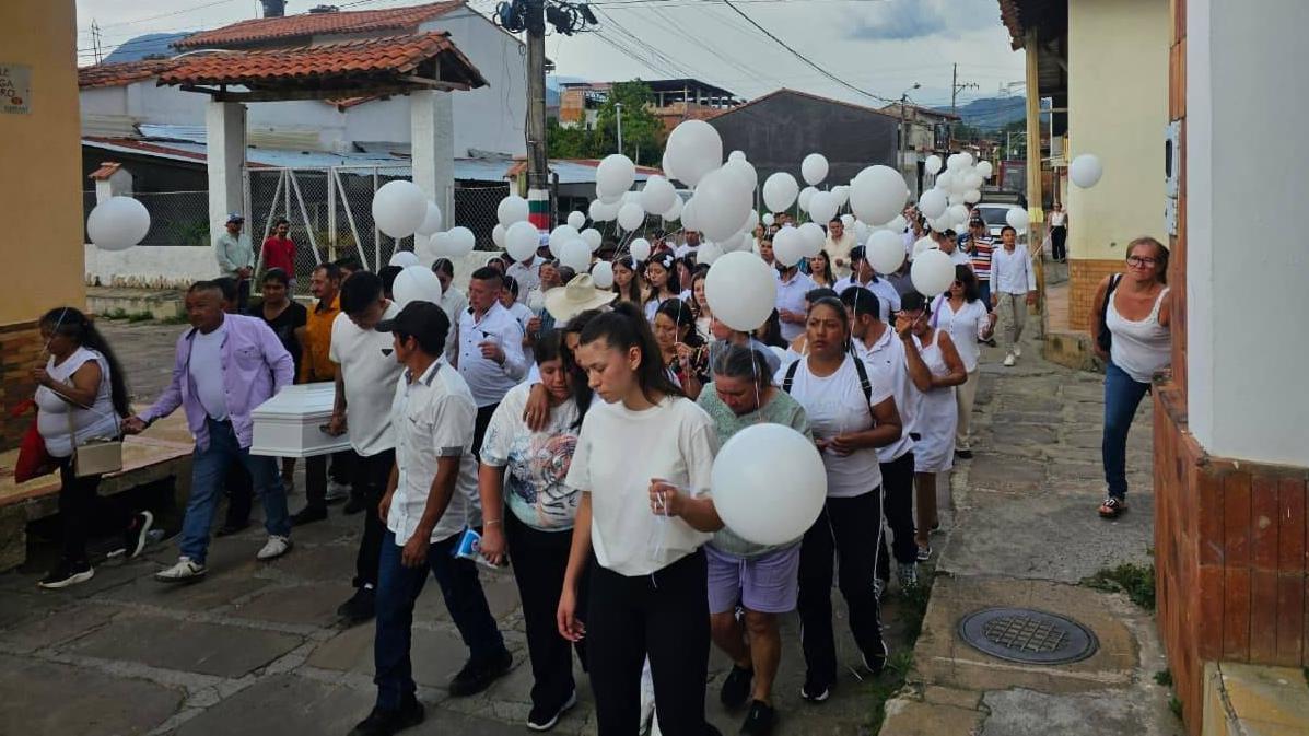Un grupo de niños y niñas con camisetas blancas y globos blancos