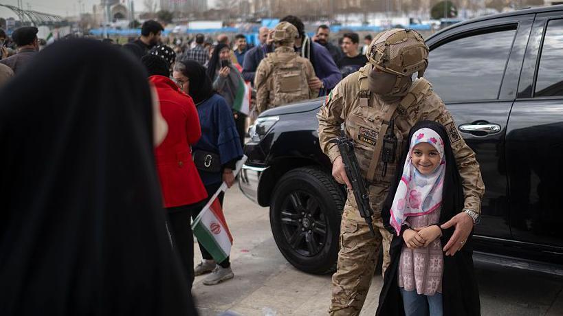 Niña en Teherán con un soldado.