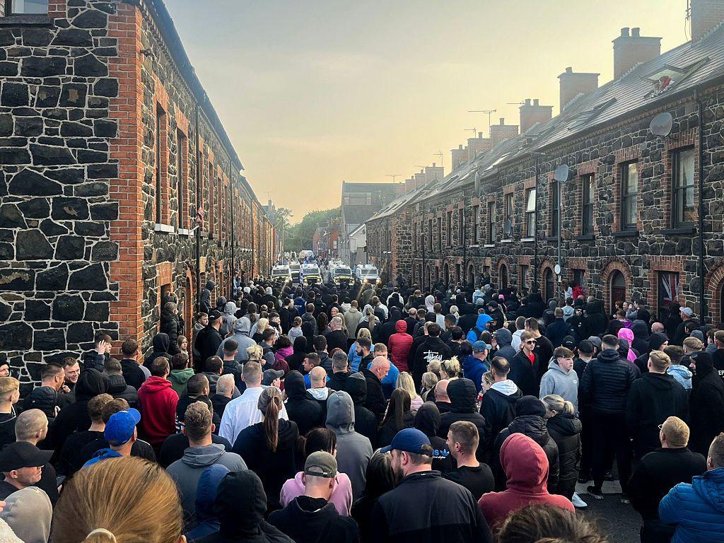 Decenas de personas ante una barricada policial en Irlanda del Norte el lunes.
