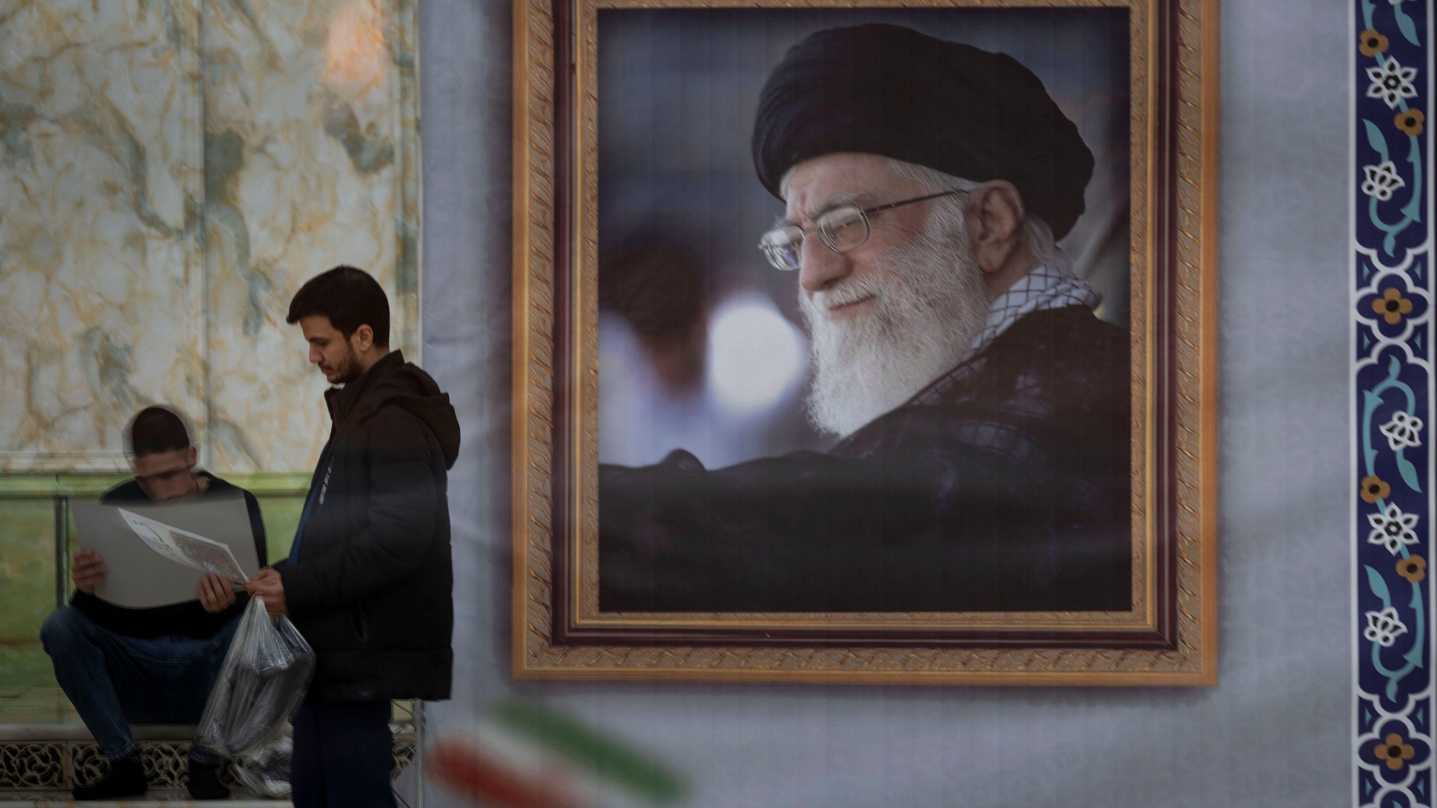يقف رجل إيراني بجوار صورة المرشد الأعلى الإيراني، آية الله علي خامنئي، بعد مشاركته في مراسم إحياء الذكرى السابعة والأربعين لانتصار الثورة الإسلامية الإيرانية في ضريح آية الله الخميني في مقبرة بهشت ​​زهراء جنوب طهران، إيران، في 1 فبراير/شباط 2026 