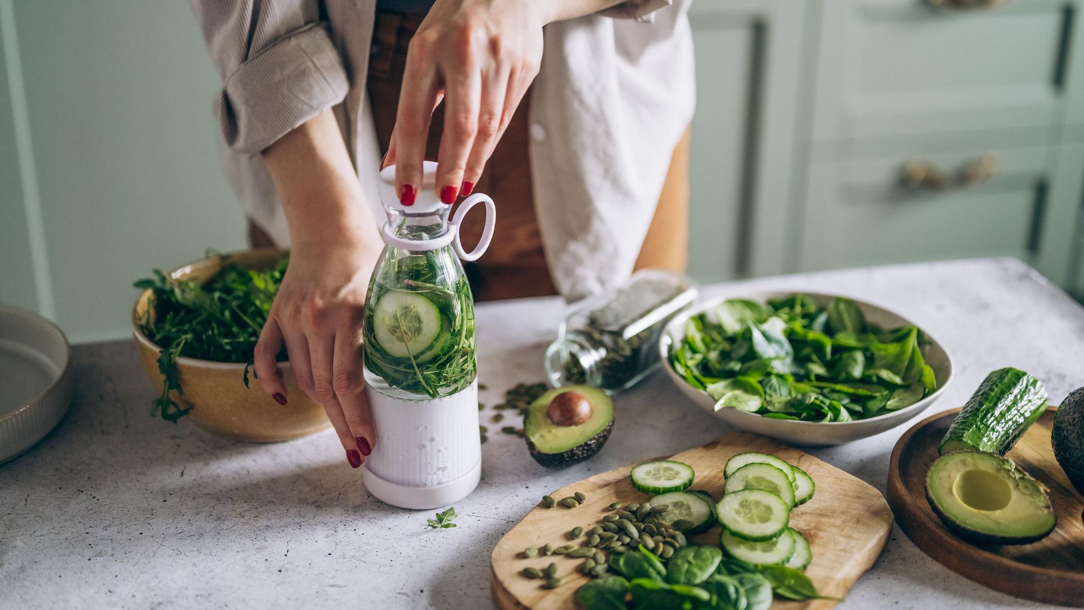 Mulher preparando refei&ccedil;&atilde;o com muitos vegetais verdes