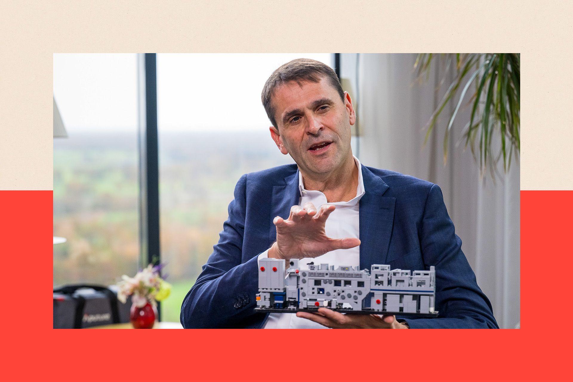 艾斯摩爾執行長克里斯多夫・富凱（Christophe Fouquet）手持一台半導體微影機的模型。