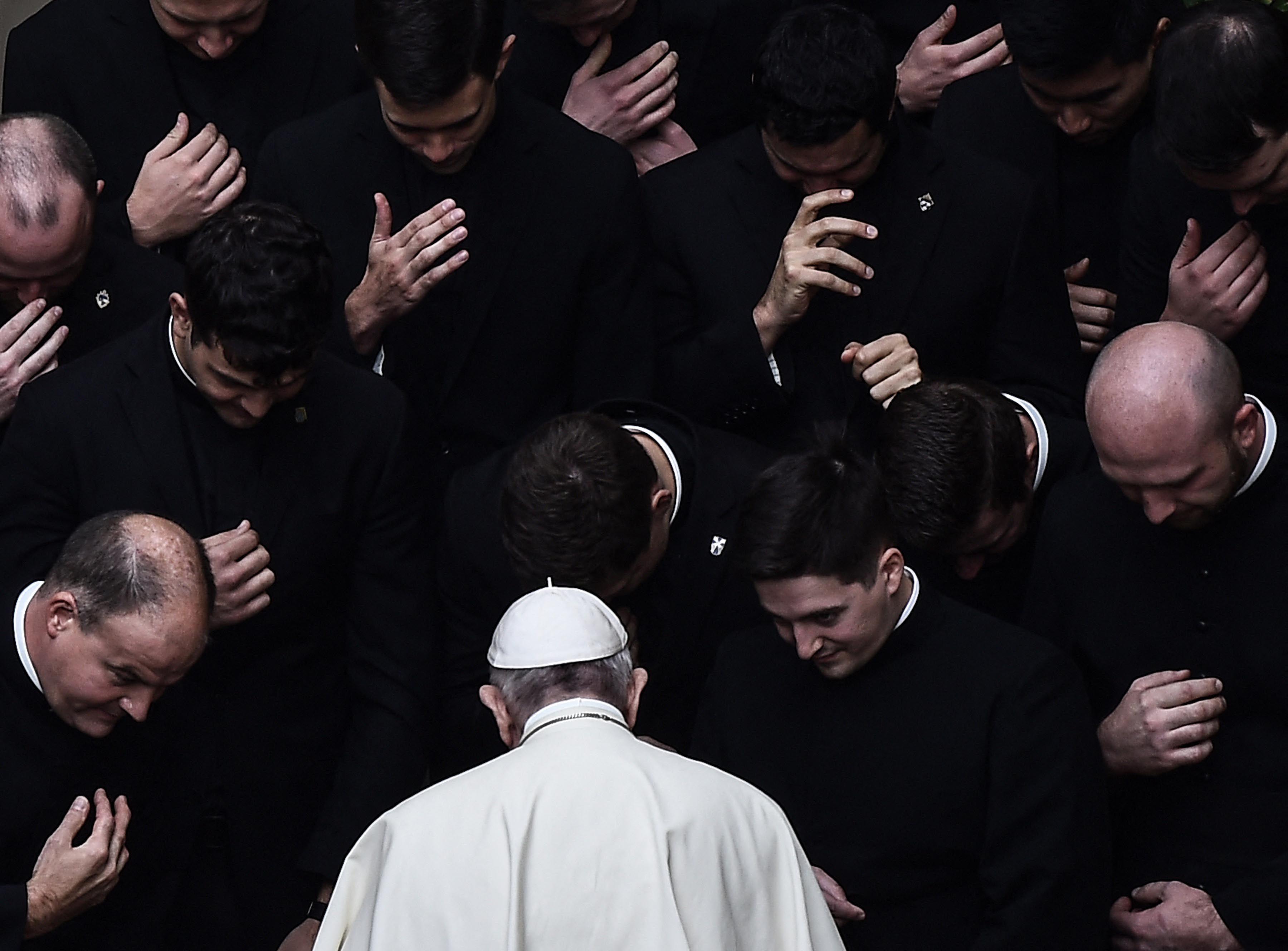 Papa Francisco rezando cercado por outros sacerdotes