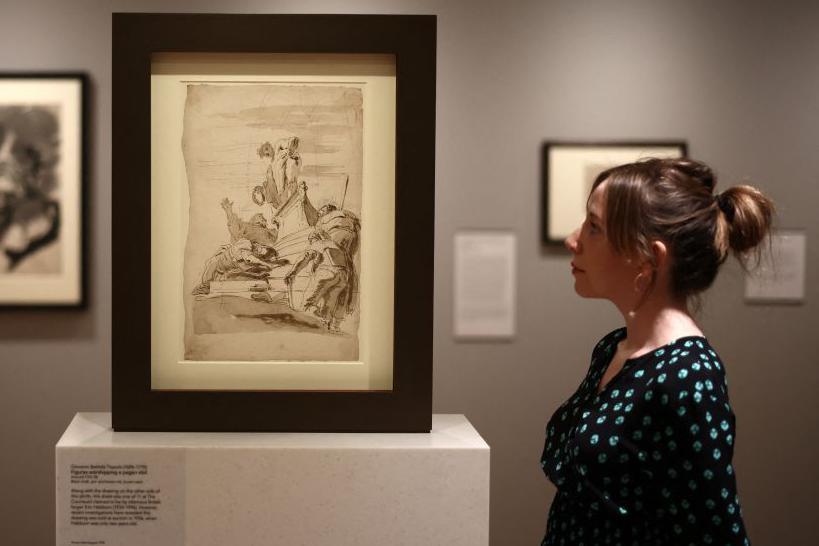 Una asistente de galería examina la obra "Figuras adorando a un ídolo pagano", que se cree fue creada originalmente por el falsificador británico Eric Hebborn, pero que recientemente se ha comprobado que esto es incorrecto.