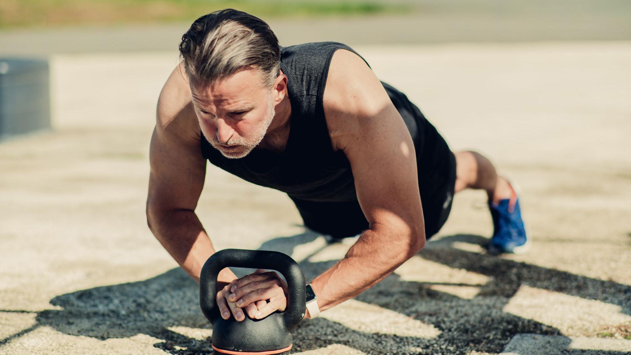 Un hombre realiza ejercicios isométricos en un parque.
