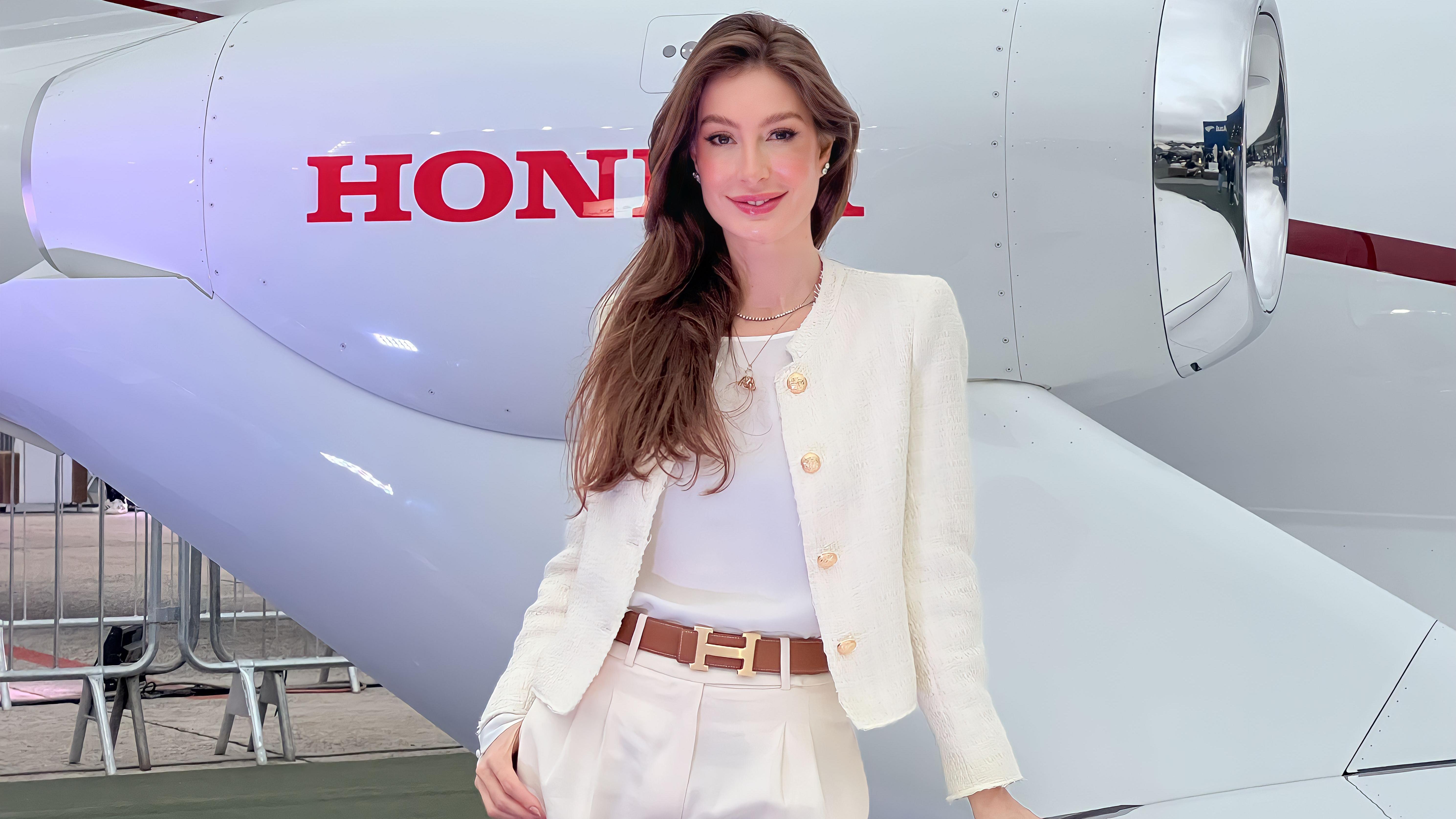 Mulher com olhar confiante em frente a jatinho